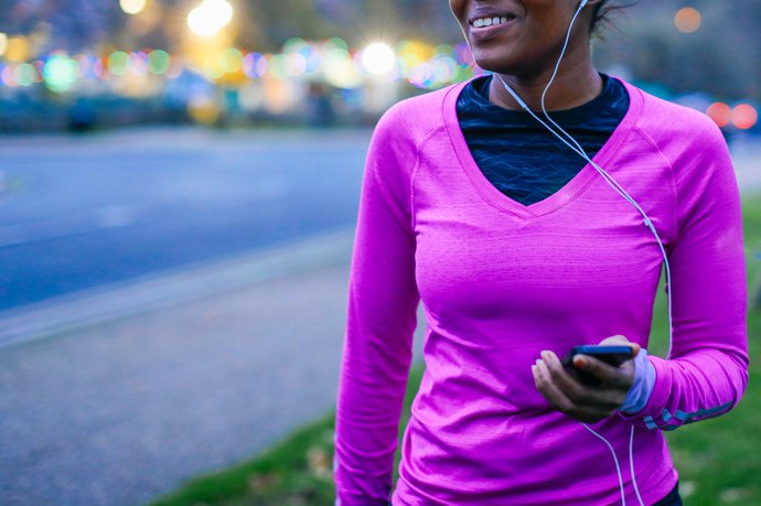 A woman wearing exercise clothing with headphones in